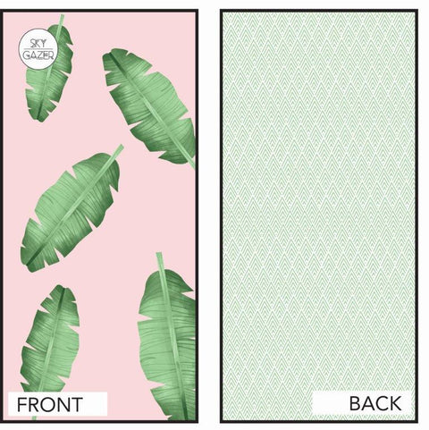 The Balmoral Sky Gazer sand free towel is being displayed, showing the back pattern which has green zig zags and the front pattern which has a green and pink leafy design.