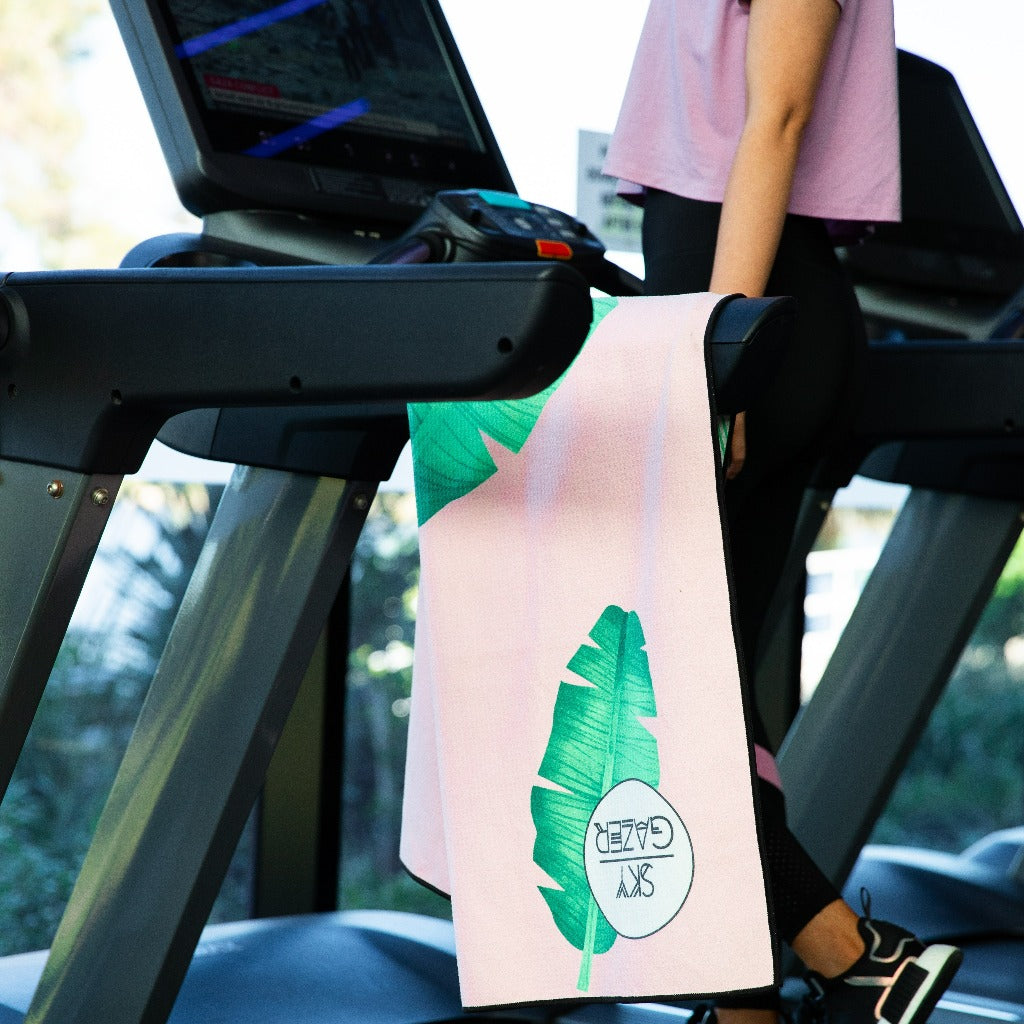 the Balmoral Sky Gazer ultra absorbant beach towel is hanging on a treadmill in a gym