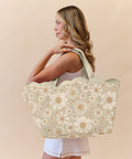 Woman holding a floral-patterned scallop beach tote bag against a beige background