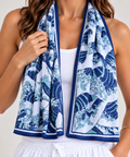 A woman models a navy blue and white Ghibli-inspired wave cooling towel draped around her neck, paired with a white tank top and white drawstring shorts against a light gray studio background.