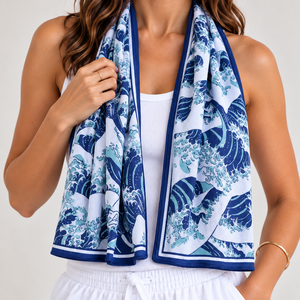 A woman models a navy blue and white Ghibli-inspired wave cooling towel draped around her neck, paired with a white tank top and white drawstring shorts against a light gray studio background.