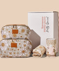 Floral-patterned cosmetic bag and toiletry bag, towel, and hair wrap with a branded box on a beige background