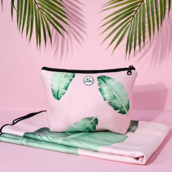 Folded Sky Gazer pink and green leafy sand-free towel with a matching wet bag.